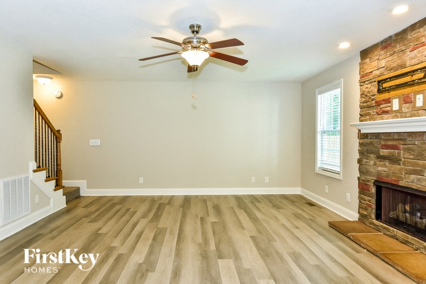 a living room with a fireplace and a ceiling fan