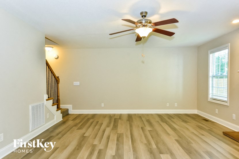 the living room with hardwood floors and a ceiling fan