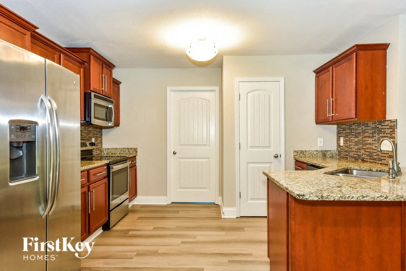 a kitchen with wood flooring and stainless steel appliances