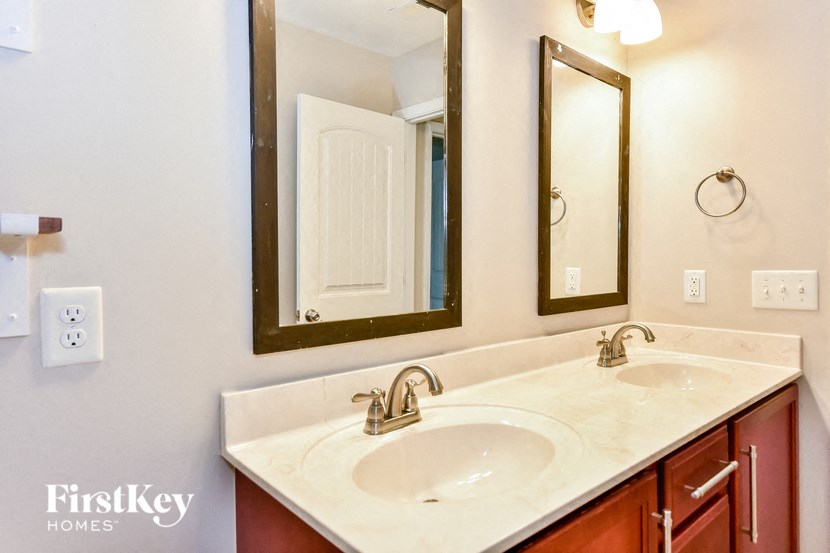 a bathroom with two sinks and two mirrors
