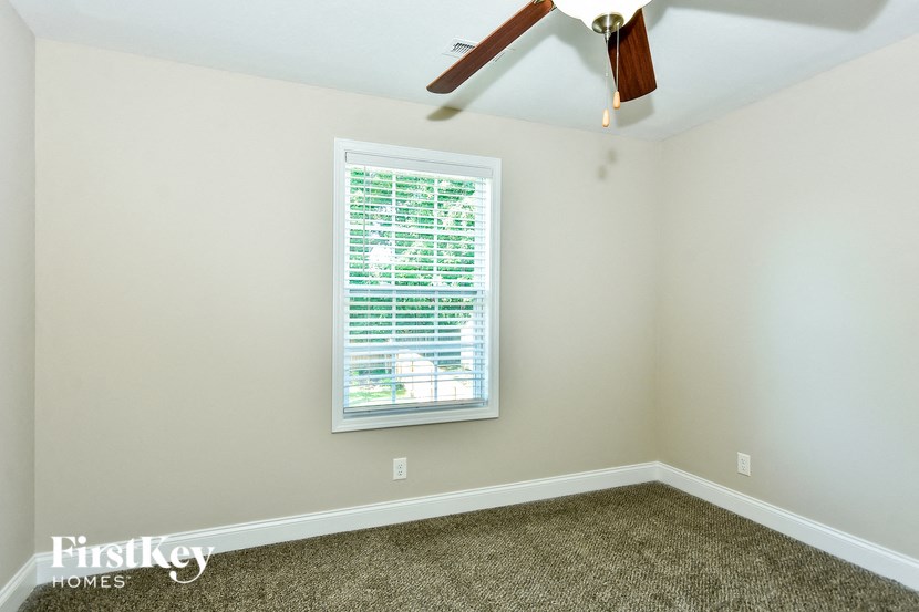 a bedroom with a window and a ceiling fan