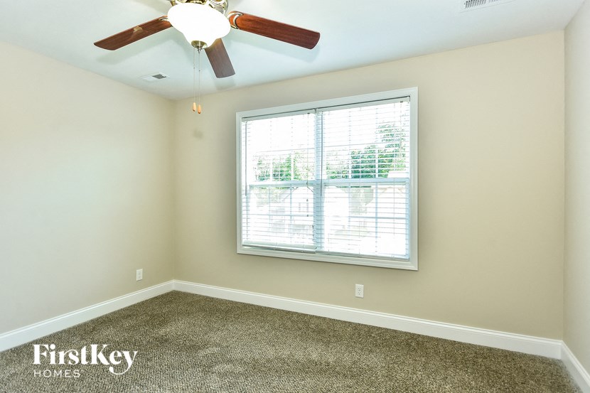 a bedroom with a ceiling fan and a window