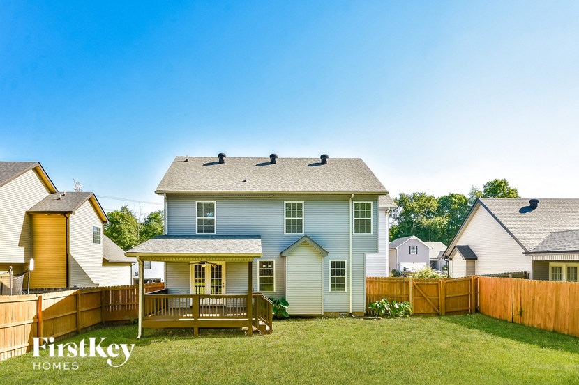 a blue house with a backyard and a wooden fence