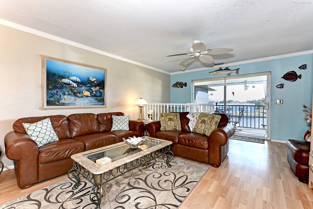 the living room has leather couches and a coffee table