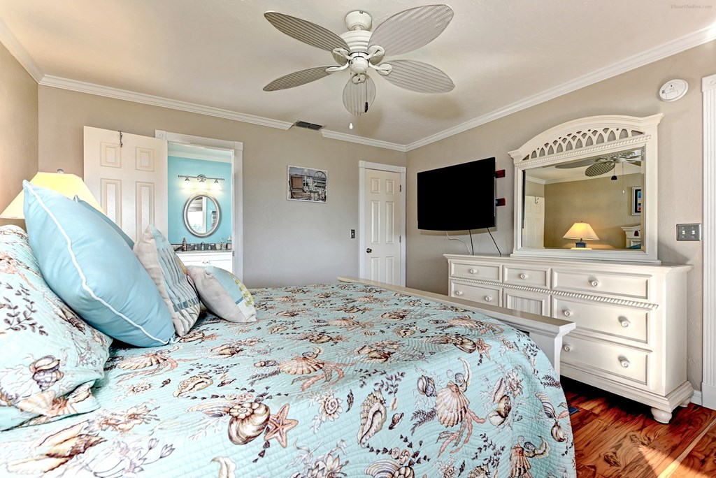 a bedroom with a large bed and a ceiling fan