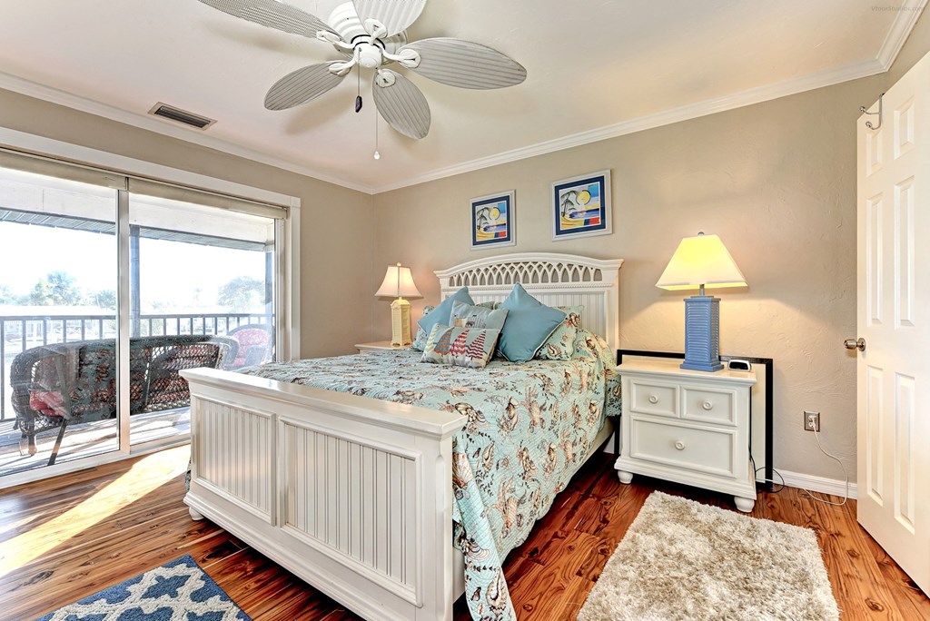 a bedroom with a bed and a ceiling fan