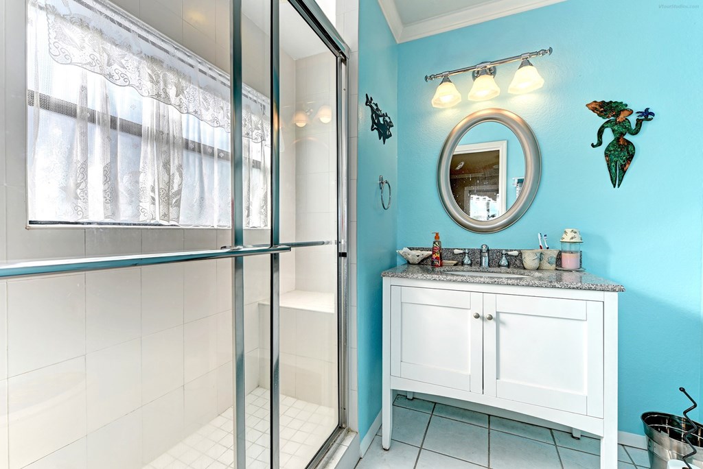 a bathroom with a shower and a sink and a mirror