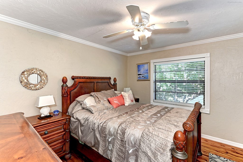 a bedroom with a large bed and a ceiling fan