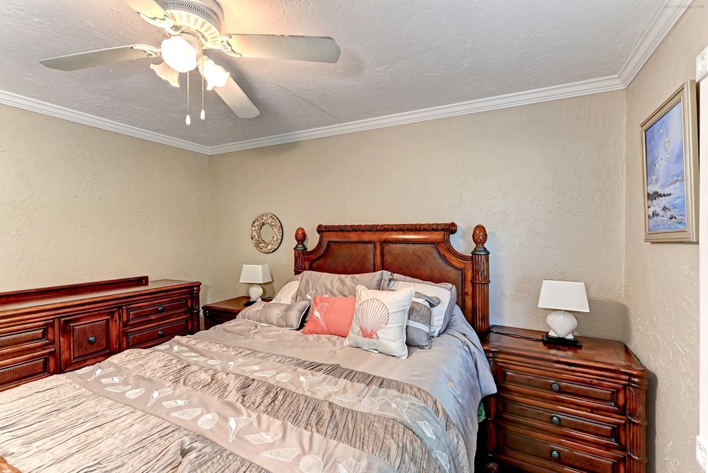 a bedroom with a bed and a ceiling fan