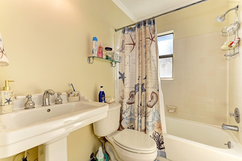 a bathroom with a sink toilet and tub and a shower curtain