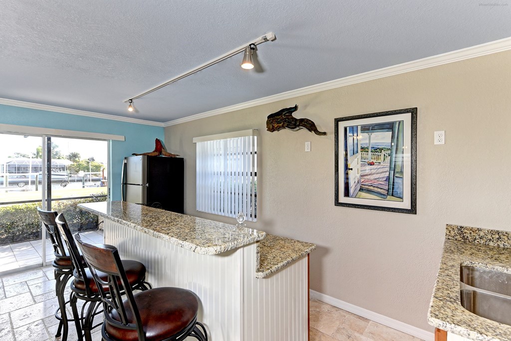 a kitchen with a bar and a door to a patio