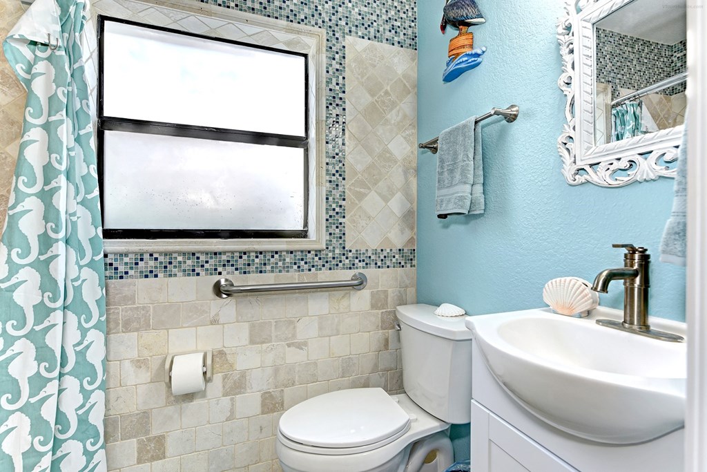 a bathroom with a toilet and a sink and a window