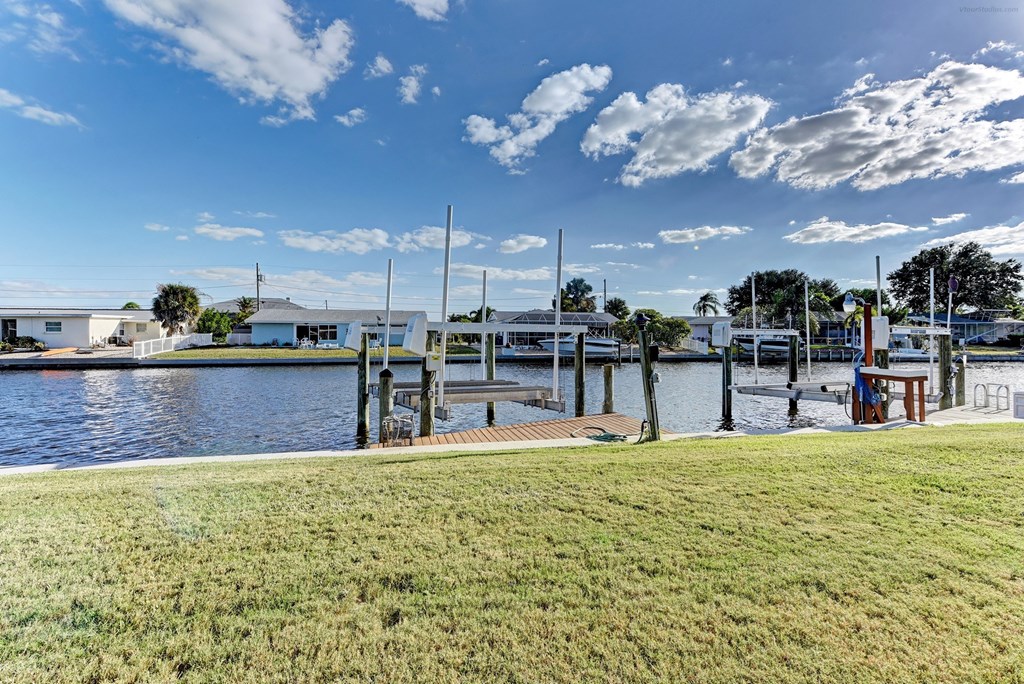 a dock on the water at a marina with houses in the background