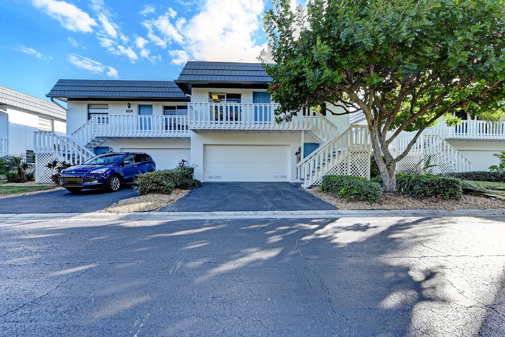 a white house with a car parked in front of it