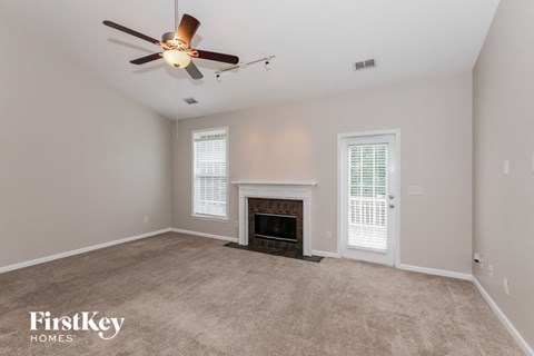 a living room with a fireplace and a ceiling fan