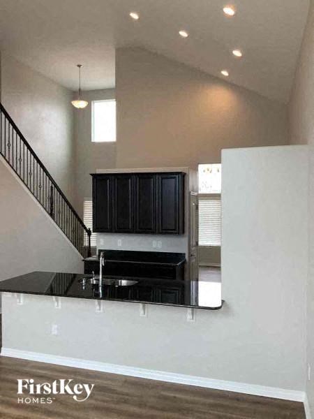 A modern kitchen with black cabinets and a stainless steel island.