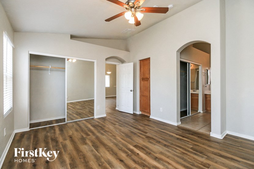 a living room with white walls and a ceiling fan