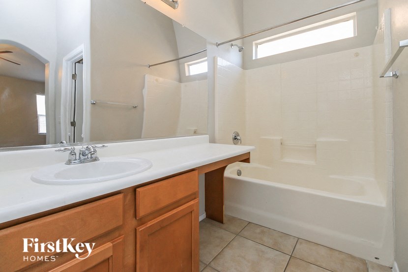 a bathroom with a sink and a tub and a mirror