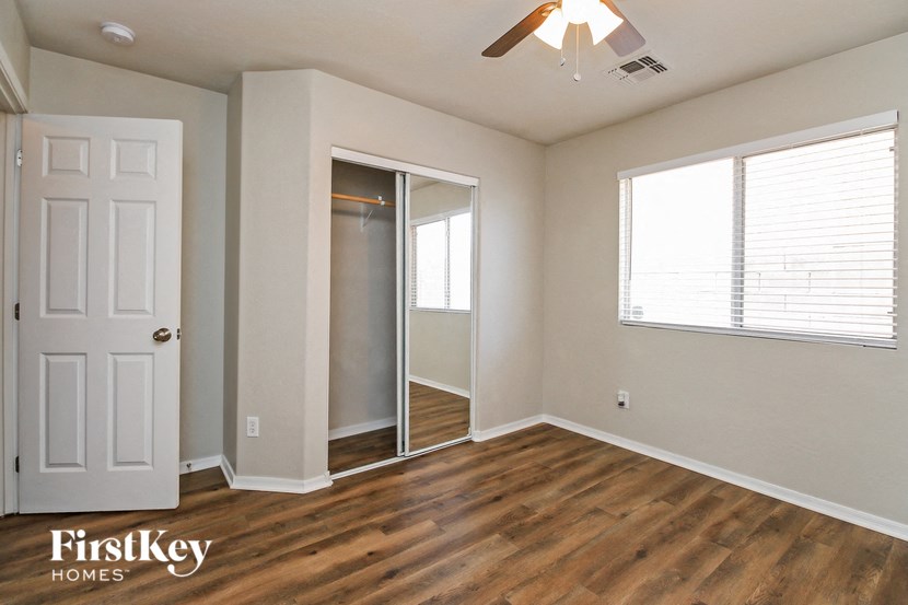 a bedroom with a door to a closet and a window