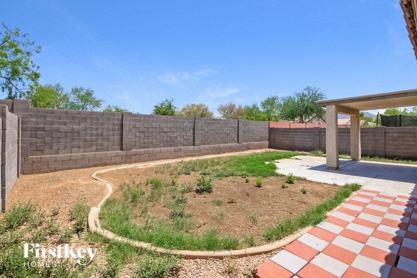 a backyard with a retaining wall and a patio with a brick fence