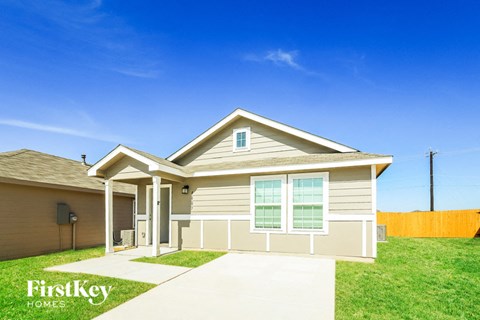 a beige house with a lawn and a sidewalk