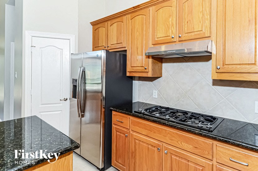 a kitchen with wooden cabinets and a stainless steel refrigerator