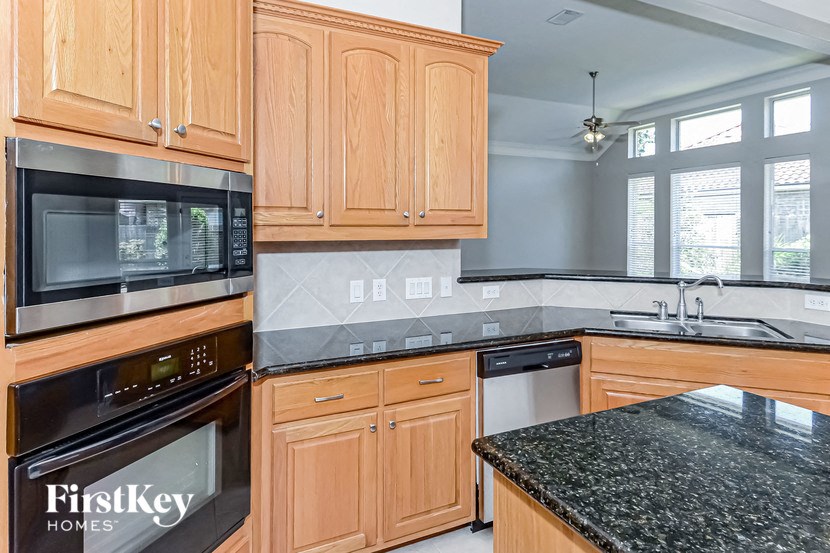 a kitchen with wooden cabinets and a black counter top