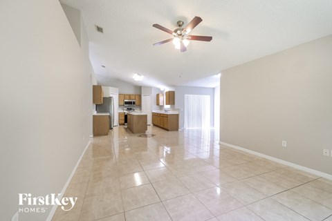 A spacious room with a ceiling fan and tiled flooring.