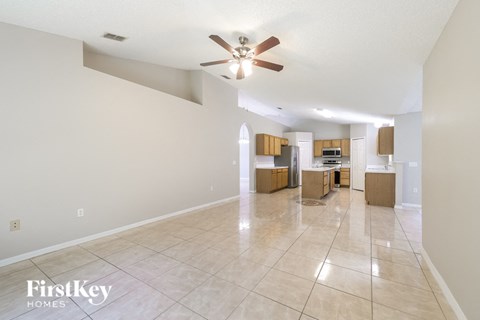 A spacious room with a ceiling fan and tiled flooring.