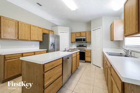 A kitchen with wooden cabinets and a refrigerator.