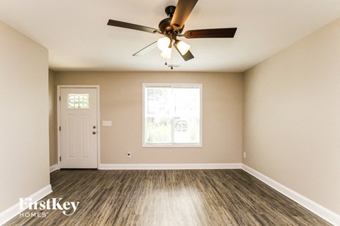 A room with a ceiling fan and a window.