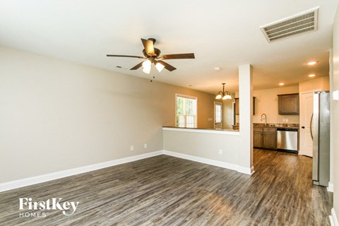 A spacious room with a ceiling fan and wooden flooring.