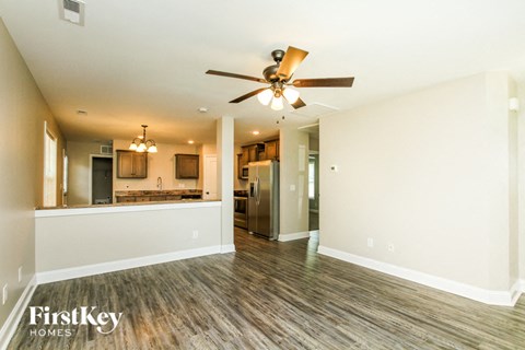 A spacious room with a ceiling fan and wooden flooring.