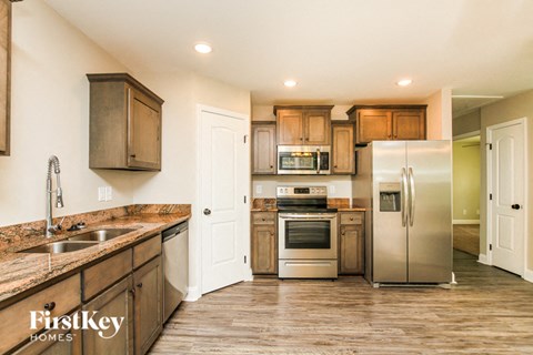 A kitchen with wooden cabinets and a stainless steel refrigerator.