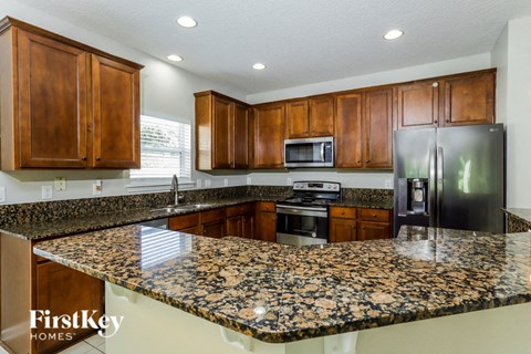A kitchen with granite countertops and wooden cabinets.