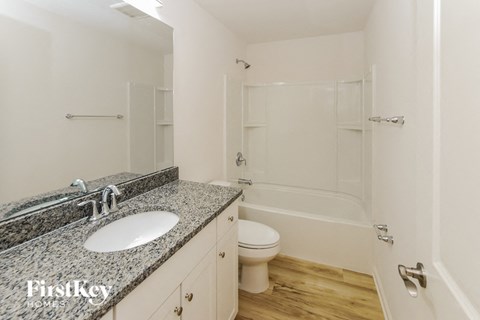 A bathroom with a marble countertop and a white toilet.