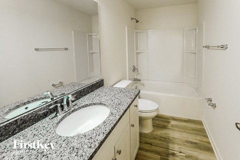 A bathroom with a sink, toilet, and bathtub.