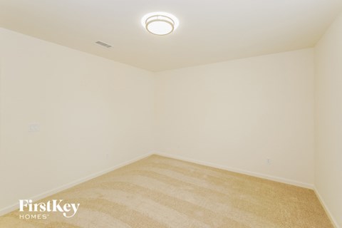 A room with a carpeted floor and a ceiling light.