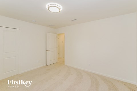 A room with a light on the ceiling and a door on the left.