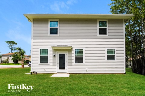 A white house with a black door and windows.