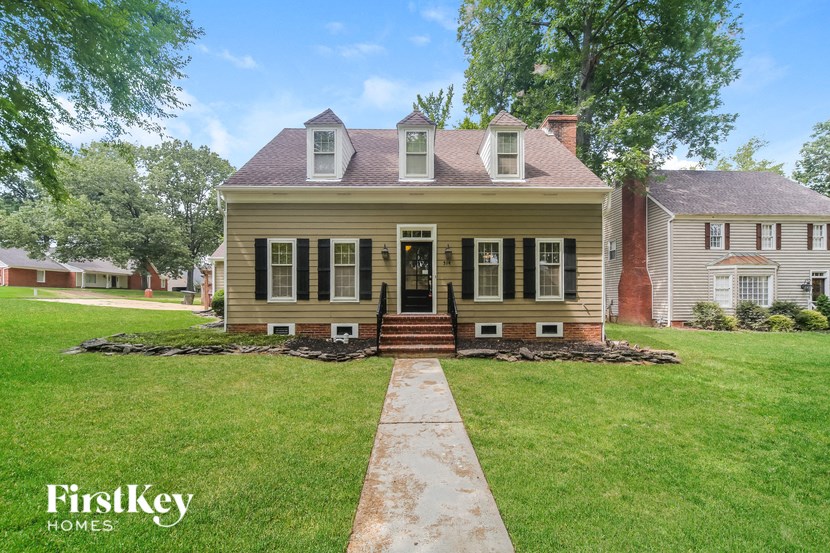 a house with a lawn and a sidewalk in front of it