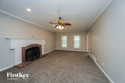 a living room with a fireplace and a ceiling fan