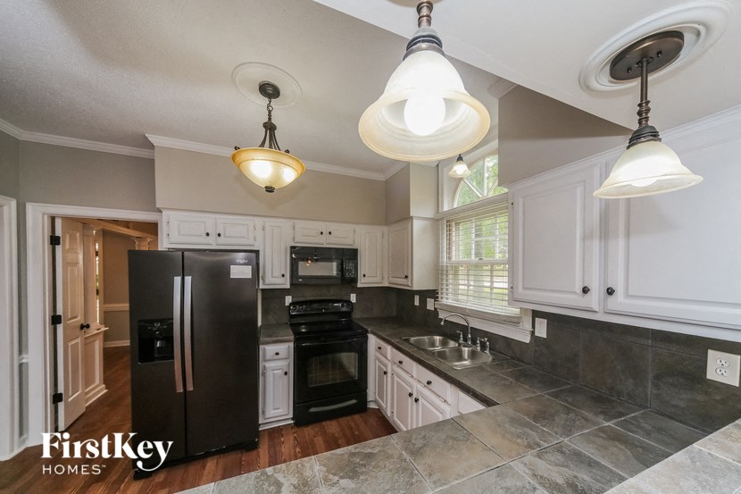 a kitchen with black appliances and white cabinets