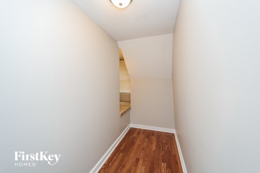 an empty room with a hardwood floor and white walls