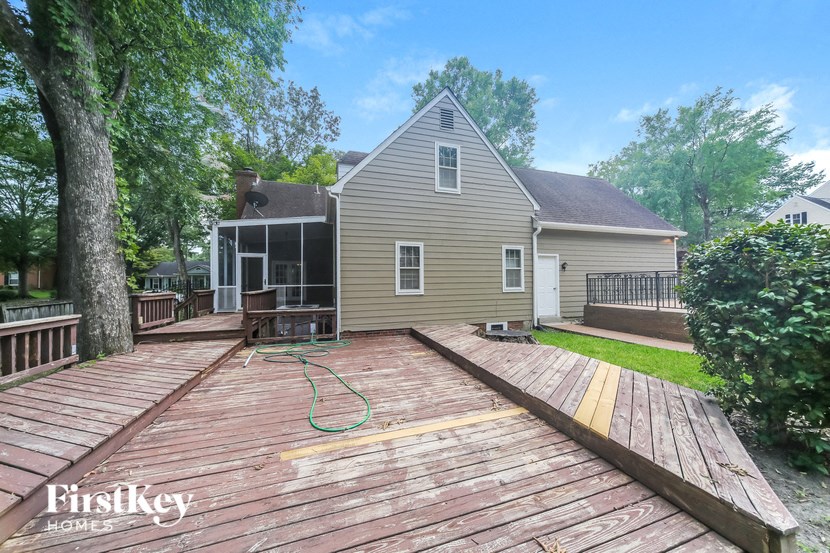 a backyard deck with a house in the background