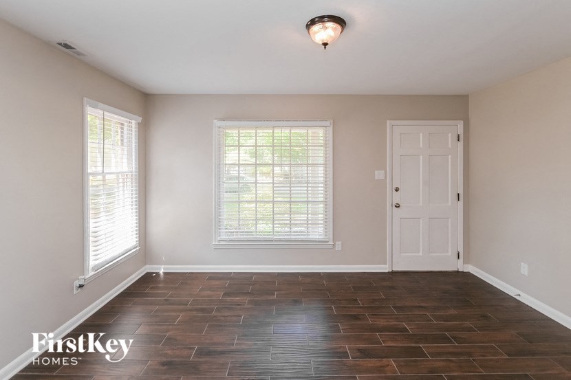 the living room of an empty house with a white door and window