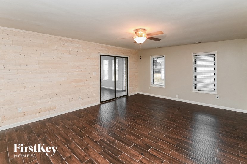 an empty living room with wood floors and a sliding glass door