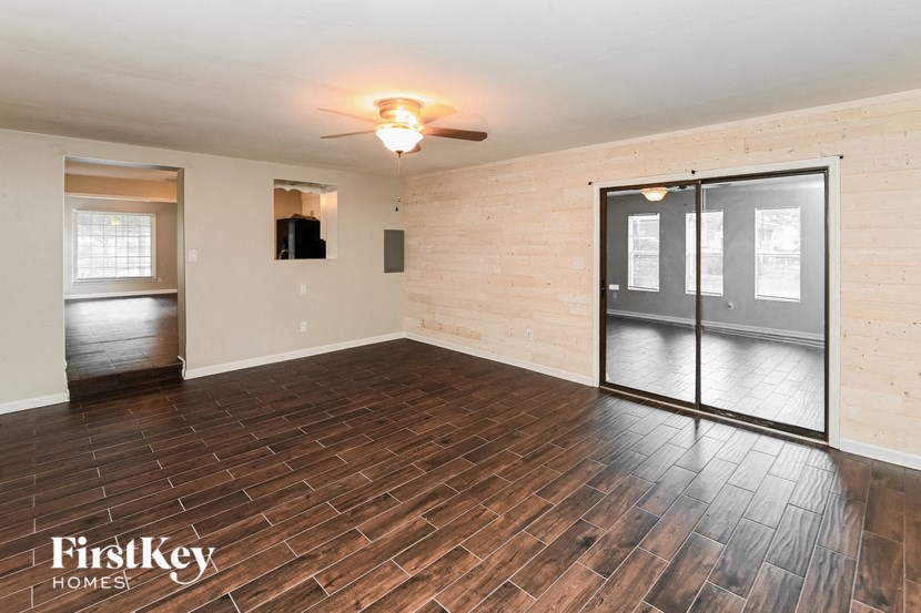 an empty living room with wood flooring and a sliding glass door