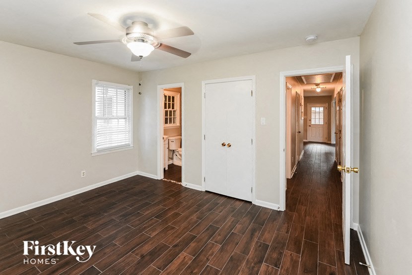 an empty living room and hallway with a ceiling fan