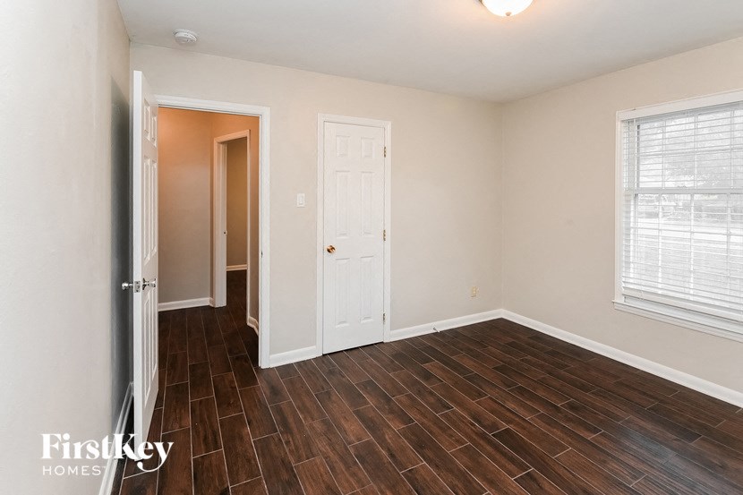 the living room of a home with a wood floor and a white door